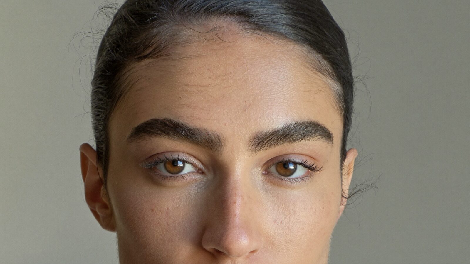 Close portrait of a woman with full, natural, well-shaped eyebrows
