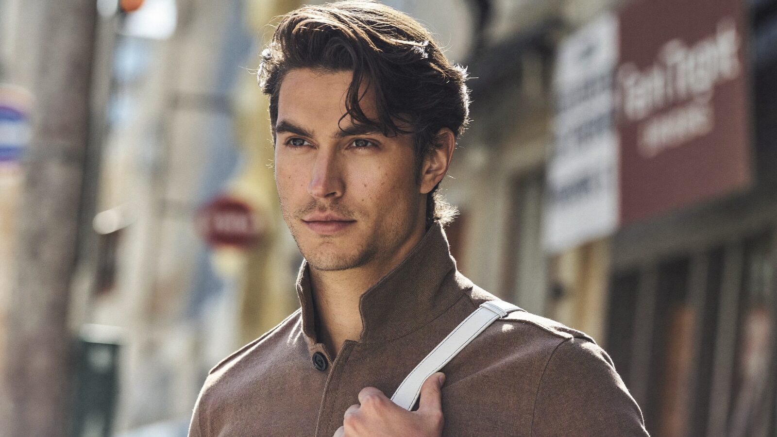 Man with medium-length styled hair on a city street