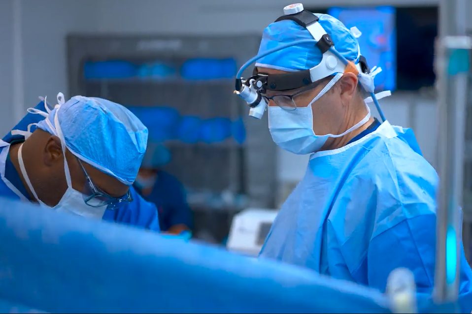 Surgical team in masks and magnifying loupes working in an operating room at Nova Medical Hair Transplant Chicago